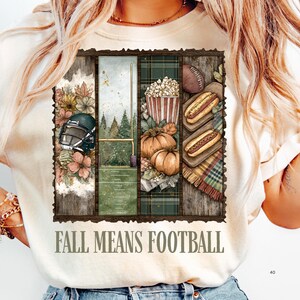May include: Cream-colored t-shirt with a rectangular graphic featuring football-themed illustrations. The graphic includes a football helmet, a football field, pumpkins, popcorn, hot dogs, and the text "FALL MEANS FOOTBALL."