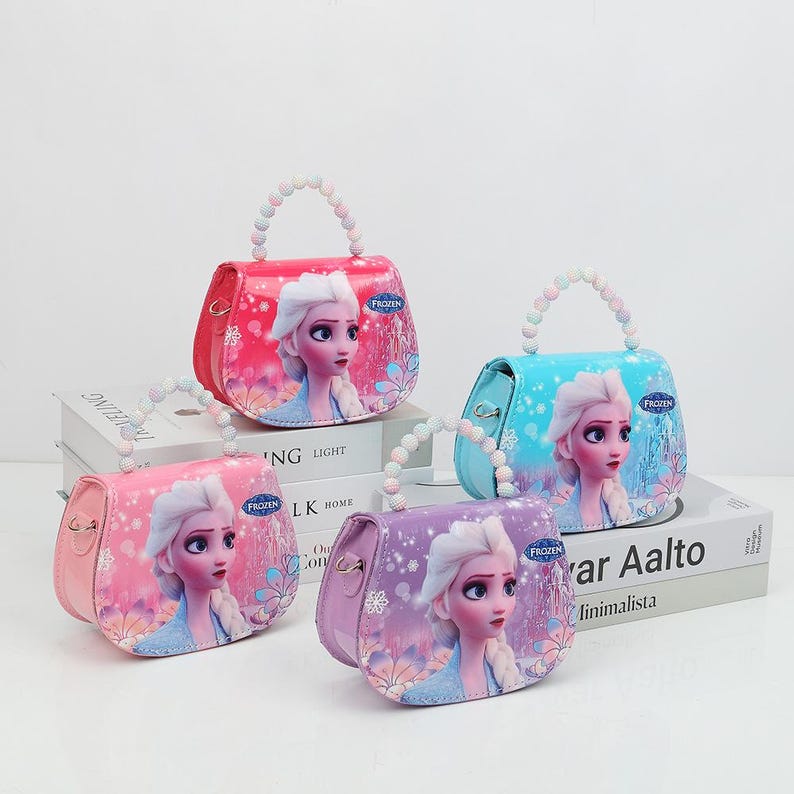 May include: Four colorful purses with beaded handles. Each purse features a portrait of a princess from the movie "Frozen". The purses are in pink, red, blue, and purple. The purses have a rounded shape and a small size.