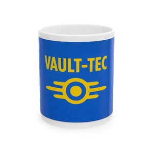 May include: A white ceramic mug with a blue band featuring the text "VAULT-TEC" in yellow, above a yellow emblem. The mug is cylindrical and suitable for hot or cold drinks. The design is inspired by the Fallout video game series.