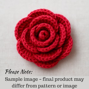 Könnte beinhalten: Eine handgefertigte, leuchtend rote Häkelrose. Die Blüte ist voll erblüht, mit eng gewickelten Blütenblättern, die ein spiralförmiges Zentrum bilden. Das Bild enthält den Text "Please Note: Sample image - final product may differ from pattern or image."