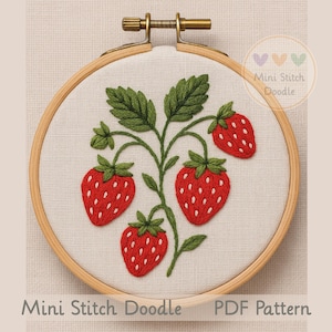 May include: Embroidered strawberry design in a wooden hoop. The artwork features four red strawberries with white seed details and green leaves. The text "Mini Stitch Doodle PDF Pattern" is at the bottom.