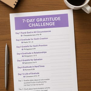 May include: A 7-Day Gratitude Challenge sheet with a purple header and text detailing daily gratitude themes and Bible verses. A silver pen, a cup of coffee, and a spiral notebook are also on the wooden surface.