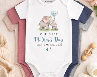 May include: White baby onesie with a watercolor illustration of two elephants and the text "OUR FIRST Mother's Day". The design includes a blue heart-shaped balloon that says "I love you". The text also includes the names "Liam & Mommy 2026".