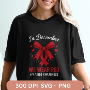 Pode incluir: Camiseta preta com o texto "In December, We Wear Red, HIV/AIDS Awareness". O design apresenta uma grande fita vermelha e pequenos corações vermelhos. A parte inferior da imagem inclui o texto "300 DPI SVG - PNG."