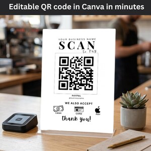 Könnte beinhalten: Weißes Acrylschild mit einem QR-Code für die Bezahlung. Das Schild lautet "SCAN to Pay" und enthält Symbole für Bargeld, Karte und Apple Pay. Der Text "Editable QR code in Canva in minutes" steht oben.
