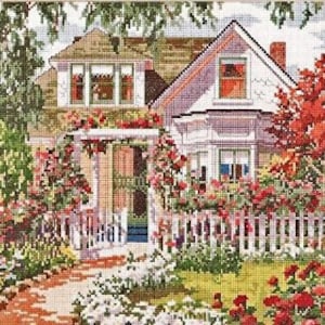 May include: A white house with a green roof and a white picket fence. The house is surrounded by a lush green lawn and a garden with red roses.