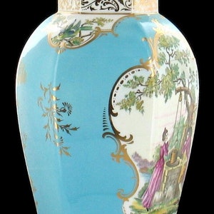 May include: A blue and white porcelain jar with a gold lid and intricate floral and bird designs. The jar has a octagonal shape and features a scene of a woman drawing water from a well.