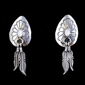 Puede incluir: Un par de pendientes de plata con una piedra blanca y detalles de plumas.