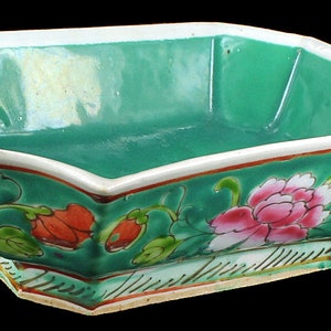 Peut inclure: Un bol en porcelaine octogonal vert avec des motifs floraux en rose, rouge et vert. Le bol a un bord blanc et une finition brillante.