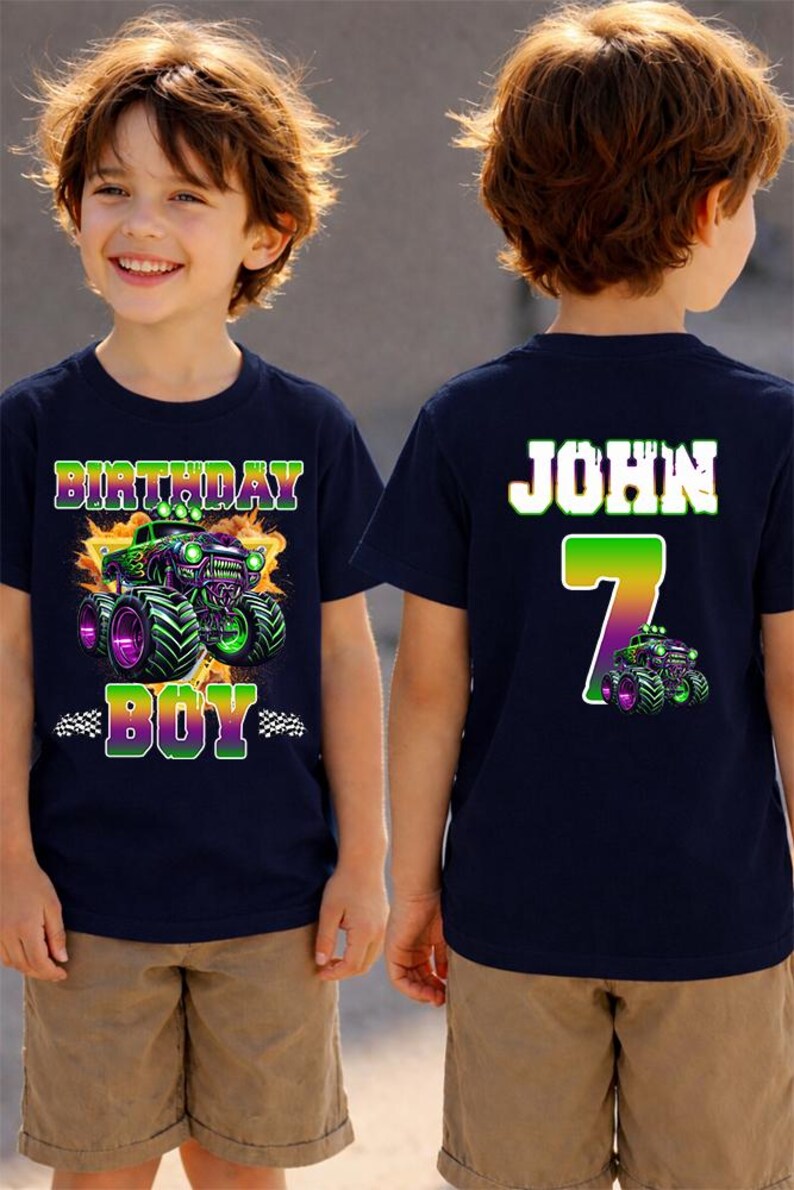 K&ouml;nnte beinhalten: Marineblaues Geburtstags-T-Shirt mit einem Monster-Truck-Motiv in Gr&uuml;n und Lila. Auf der Vorderseite des Shirts steht "BIRTHDAY BOY". Auf der R&uuml;ckseite des Shirts stehen der Name "JOHN" und die Zahl "7".