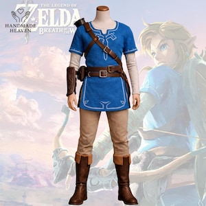 Op de afbeelding: Een blauwe tuniek met witte randen, een bruine leren riem en bijpassende bruine laarzen. Het kostuum bevat een bruine leren schouderriem en een bruine armbeschermer. De outfit is geïnspireerd op het videospel "The Legend of Zelda: Breath of the Wild".