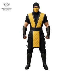 Può includere: Action figure dettagliata di un personaggio in costume nero e giallo. La figura indossa un cappuccio, una maschera e pantaloni neri, con un gilet trapuntato giallo e protezioni per le braccia. La figura è su sfondo bianco. Il logo Handmade Heaven è in alto a sinistra.