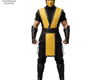 Puede incluir: Figura de acción detallada de un personaje con un disfraz negro y amarillo. La figura lleva una capucha, máscara y pantalones negros, con un chaleco acolchado amarillo y protectores de brazos. La figura está sobre un fondo blanco. El logotipo de Handmade Heaven está arriba a la izquierda.