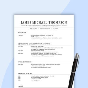 May include: A black and white resume template with the name "JAMES MICHAEL THOMPSON" at the top. The resume details education, leadership, work experience, awards, and skills. A black pen rests on the bottom right corner of the resume.