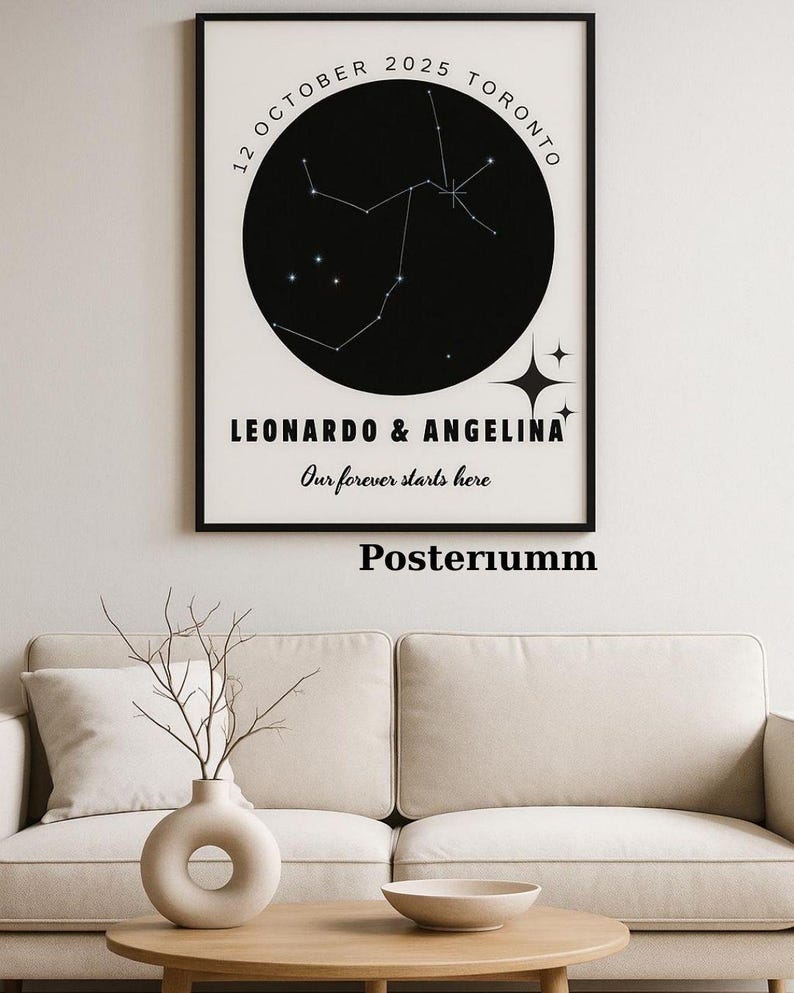 May include: A framed black and white print featuring a constellation map. The print includes the date "12 October 2025 Toronto" and the names "Leonardo & Angelina" with the text "Our forever starts here". The word "Posteriumm" is printed at the bottom.