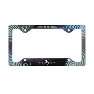 May include: A rectangular number plate frame featuring a dark space-themed background with blue swirling vortex patterns in the corners. The top edge displays the text Zeds dead, baby. and the bottom edge features a white heartbeat line with a ZD logo.