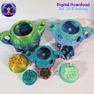 May include: Three teal and green ceramic teapots with lids and floral designs. Each teapot has a hole in the top and a base with a floral design. The teapots are on a white surface with dice inside.
