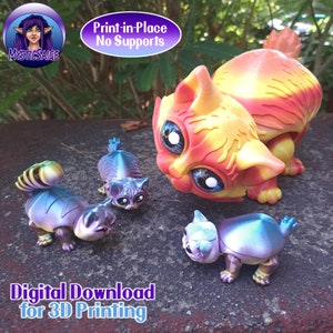 May include: Four 3D printed cat figurines, one large orange and yellow cat, and three smaller purple and blue cats. The large cat is looking down at the smaller cats. The text "Print-in-Place No Supports" and "Digital Download for 3D Printing" is visible in the image.