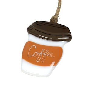 May include: A glass ornament shaped like a coffee cup with a brown lid and a white and orange body. The word "Coffee" is written in white on the orange part of the ornament.