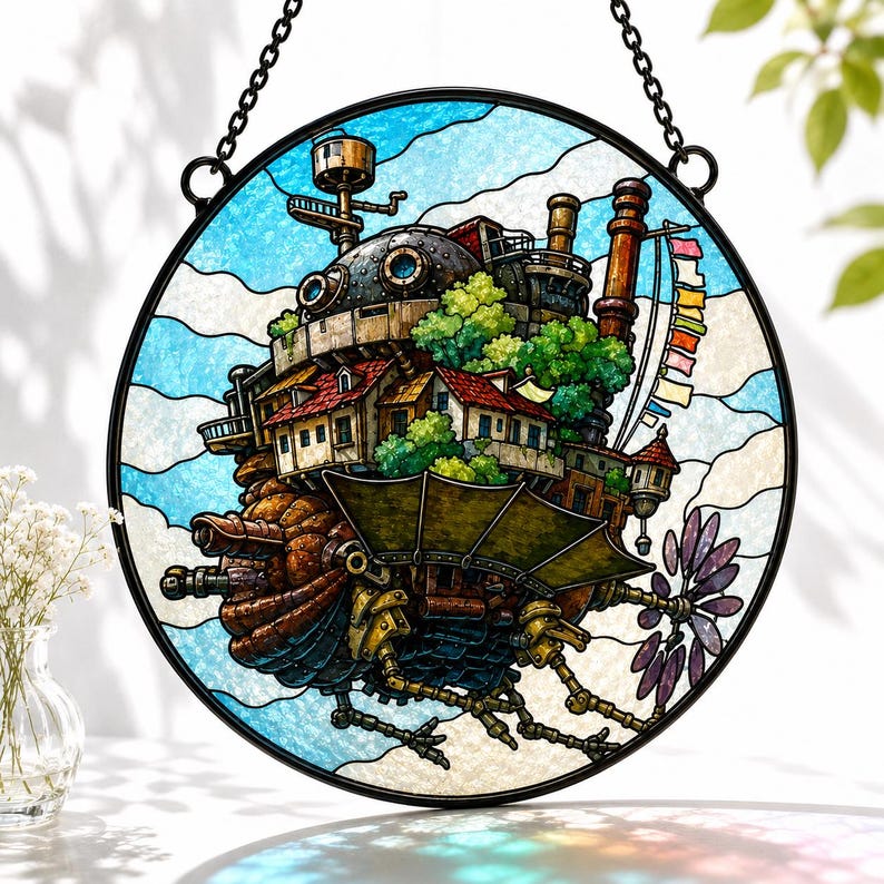 May include: A circular stained glass suncatcher featuring a detailed depiction of a mechanical walking castle with brown, rust, and green tones. The structure includes small houses with red roofs, chimneys, and a purple propeller against a blue sky.