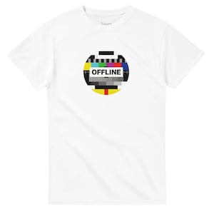 Può includere: T-shirt bianca con una grafica circolare colorata che ricorda un modello di prova televisivo. La parola "OFFLINE" è contenuta in un rettangolo bianco. La maglietta è realizzata in un materiale morbido.