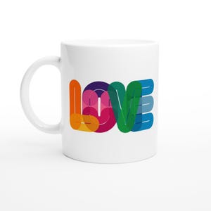 Könnte beinhalten: Weiße Keramiktasse mit dem Wort "LOVE" in einer farbenfrohen Schriftart im Regenbogenstil. Die Buchstaben sind mit Orange, Gelb, Rosa, Lila, Grün und Blautönen überlagert. Die Tasse hat einen gebogenen Griff auf der linken Seite.