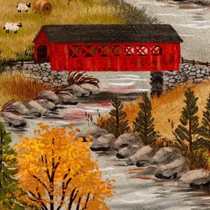 May include: A painting of a bright red covered bridge spanning a rocky stream in an autumn landscape. The scene features golden and orange trees, green pine trees, and a grassy hillside with small white sheep and a hay bale under a cloudy sky.