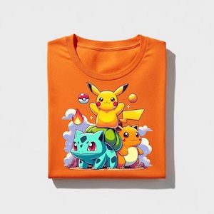 Peut inclure: T-shirt orange vif avec un dessin anim&eacute; de Pikachu, Bulbizarre et Salam&egrave;che de Pok&eacute;mon. Le motif comprend une Pok&eacute;ball, des flammes et des nuages. Le t-shirt est pli&eacute; proprement.