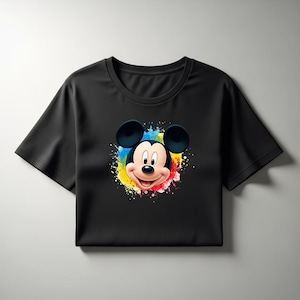 May include: Black crop top featuring a colorful graphic of Mickey Mouse's face. The design includes a vibrant splash of yellow, blue, red, and green paint around the character's head. The shirt has short sleeves and a crew neck.