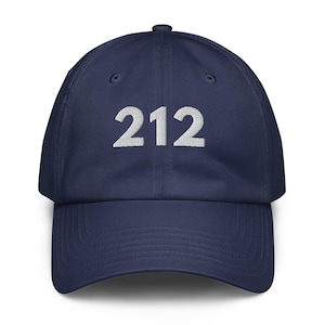 May include: Navy blue baseball cap featuring the number "212" embroidered in white. The cap has a curved peak and an adjustable strap. A classic, casual hat suitable for various occasions.