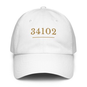 Puede incluir: Una taza de cerámica blanca con un asa negra y el texto "But First, Coffee" en negro y negrita. La taza está sobre una superficie blanca. La taza mide aproximadamente 10 cm de alto.