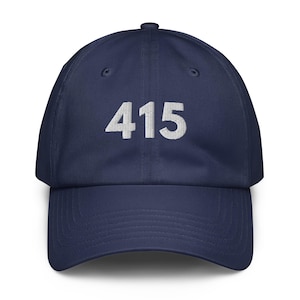 May include: Navy blue baseball cap with the number "415" embroidered in white on the front. The cap has a curved brim and an adjustable strap at the back. A classic, casual accessory.
