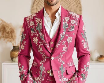 以下が含まれることがあります： 鮮やかなマゼンタ色のスリーピーススーツ。ジャケットとベストには、白い花と緑のサボテンの複雑な刺繍が施されています。中に白いボタンダウンシャツを着用しており、大胆で細部までこだわったスタイルに仕上がっています。