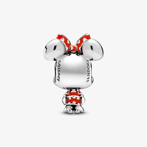 May include: A silver charm with a Minnie Mouse design. The charm features a red and white polka dot dress and bow. The charm has the Disney and Pandora logos.
