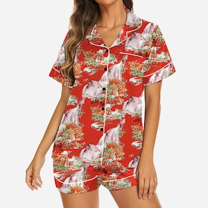 May include: Red pajama set with a repeating pattern of tigers, waterfalls, and bamboo. The short-sleeved top and shorts have white trim and black buttons. The fabric has a silky sheen.