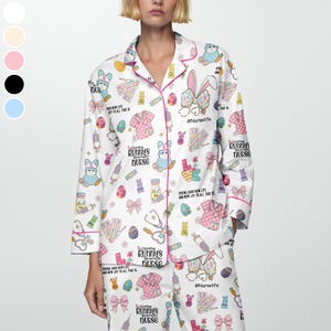 May include: White pajama set with a repeating pattern of Easter bunnies, medical supplies, and text. The set includes a button-down shirt with pink trim and matching pants. The text includes "Every bunny's favorite nurse" and "#NurseLife".