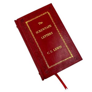 May include: A red hardcover book titled "The Screwtape Letters" by C.S. Lewis. The book features gold lettering and decorative borders. A red ribbon bookmark is visible.