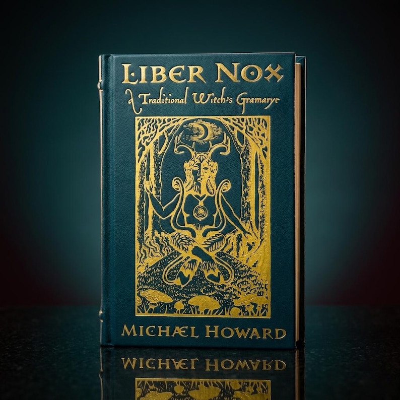 May include: A teal-colored book titled "Liber Nox: A Traditional Witch's Gramarye" with gold lettering and an illustration of a figure with antlers. The author's name, Michael Howard, is printed at the bottom in gold. The book is standing upright.