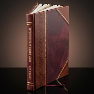 K&ouml;nnte beinhalten: Ein ledergebundenes Buch mit dem Titel "The Lesser Key of Solomon Goetia" von L.W. de Laurence. Das Buch hat einen weinroten Buchr&uuml;cken und einen braunen und weinroten Einband mit goldenen Details. Die Seiten sind sichtbar.
