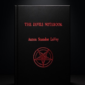 Könnte beinhalten: Ein schwarzes Buch mit dem Titel "THE DEVILS NOTEBOOK" von Anton Szandor LaVey. Das Cover zeigt ein rotes Pentagramm in einem Kreis. Der Text und das Symbol sind in einer leuchtenden, stilisierten Schrift.