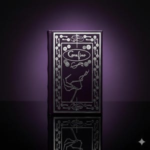 May include: A dark purple book with silver embossed details. The cover features the title "Coraline" in an oval, surrounded by keys, buttons, and a skeletal hand. The book's spine is also dark purple.