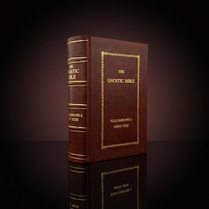May include: Two brown leather-bound books titled "The Gnostic Bible" with gold lettering and detailing. The spine of one book displays the title and author's name. The other book is open, displaying the title and author's name.