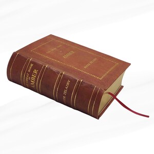 May include: A hardcover book titled "The Great Book of Amber" by Roger Zelazny. The book has a brown leather cover with gold lettering and detailing. A red ribbon bookmark is visible.