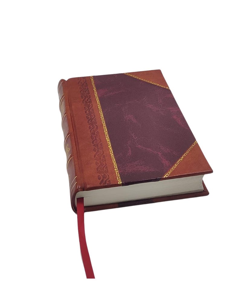 K&ouml;nnte beinhalten: Ein Hardcover-Journal mit burgunderfarbenem Einband und dekorativem Goldrand. Der Buchr&uuml;cken ist dunkler braun, und ein rotes Leseb&auml;ndchen ragt aus den Seiten. Die Seiten des Journals sind wei&szlig;.