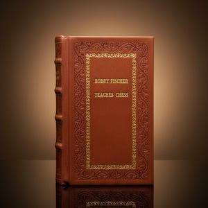 Peut inclure: Un livre à couverture rigide marron-rouge intitulé "Bobby Fischer Teaches Chess". Le livre présente des bordures et un texte dorés. La tranche comporte des bandes en relief. Le livre est debout.