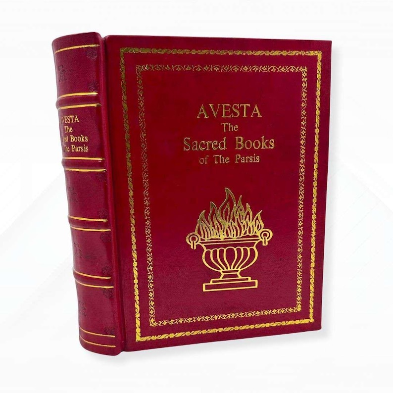 Op de afbeelding: Een decoratief rood boek met gouden letters en een gouden rand. De titel luidt "AVESTA The Sacred Books of The Parsis." De rug is rood met gouden lijnen en de tekst "AVESTA The Books of The Parsis."