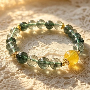Könnte beinhalten: Ein Armband mit durchscheinenden grünen und gelben Edelsteinperlen. Das Armband hat runde, klare grüne Perlen und eine einzelne, größere gelbe Perle. Goldfarbene Akzente sind zwischen den Perlen sichtbar.