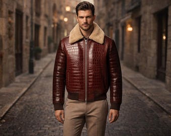 May include: A burgundy leather jacket with a textured crocodile pattern and a tan fur collar. The jacket has a zipper closure and brown ribbed cuffs and hem. The person is wearing khaki pants.