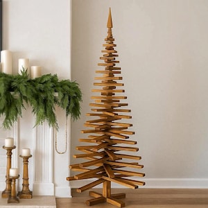 Könnte beinhalten: Ein hoher, freistehender Weihnachtsbaum aus gestapelten, horizontalen Holzlatten in natürlicher brauner Ausführung, mit einer spitzen Spitze und einem kreuzförmigen Sockel, stehend auf einem hellen Holzboden.