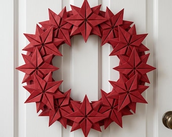 Könnte beinhalten: Ein kreisförmiger Kranz aus mehreren dunkelroten, achtstrahligen Origami-Sternen. Jeder Stern weist scharfe, geometrische Falten und ein symmetrisches Design auf, die in einem dichten, überlappenden Muster zu einem Ring angeordnet sind.